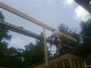 Carpenter setting a ridge beam over a new addition frame — Ice Dam Removal by Roofing Brothers in Oakesdale