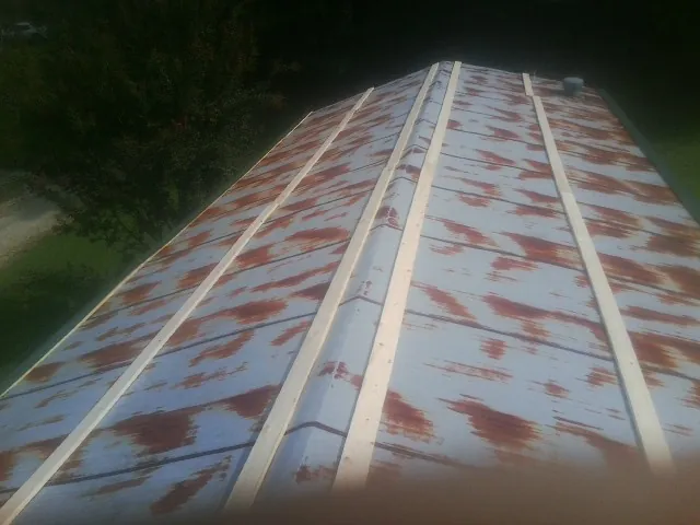 Rusted metal roof panels with new wood purlins before replacement — Storm Damage Roof Repair in Oakesdale by Roofing Brothers
