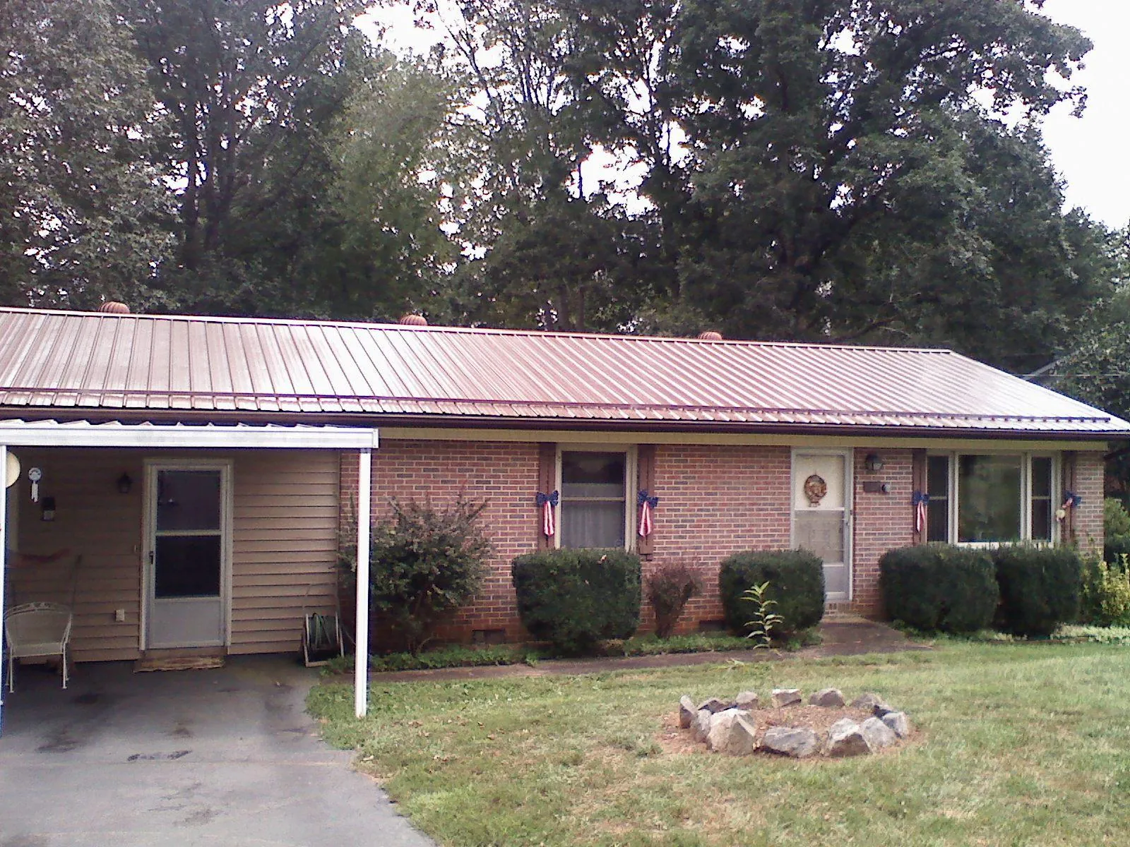 Bronze metal roof and carport on a brick ranch home — Roof Repair work by our crew in Oakesdale